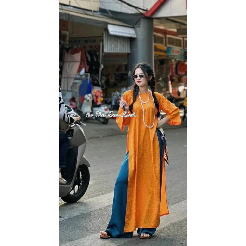 Innovative orange brocade ao dai with youthful loose shape - Dan Linh ...